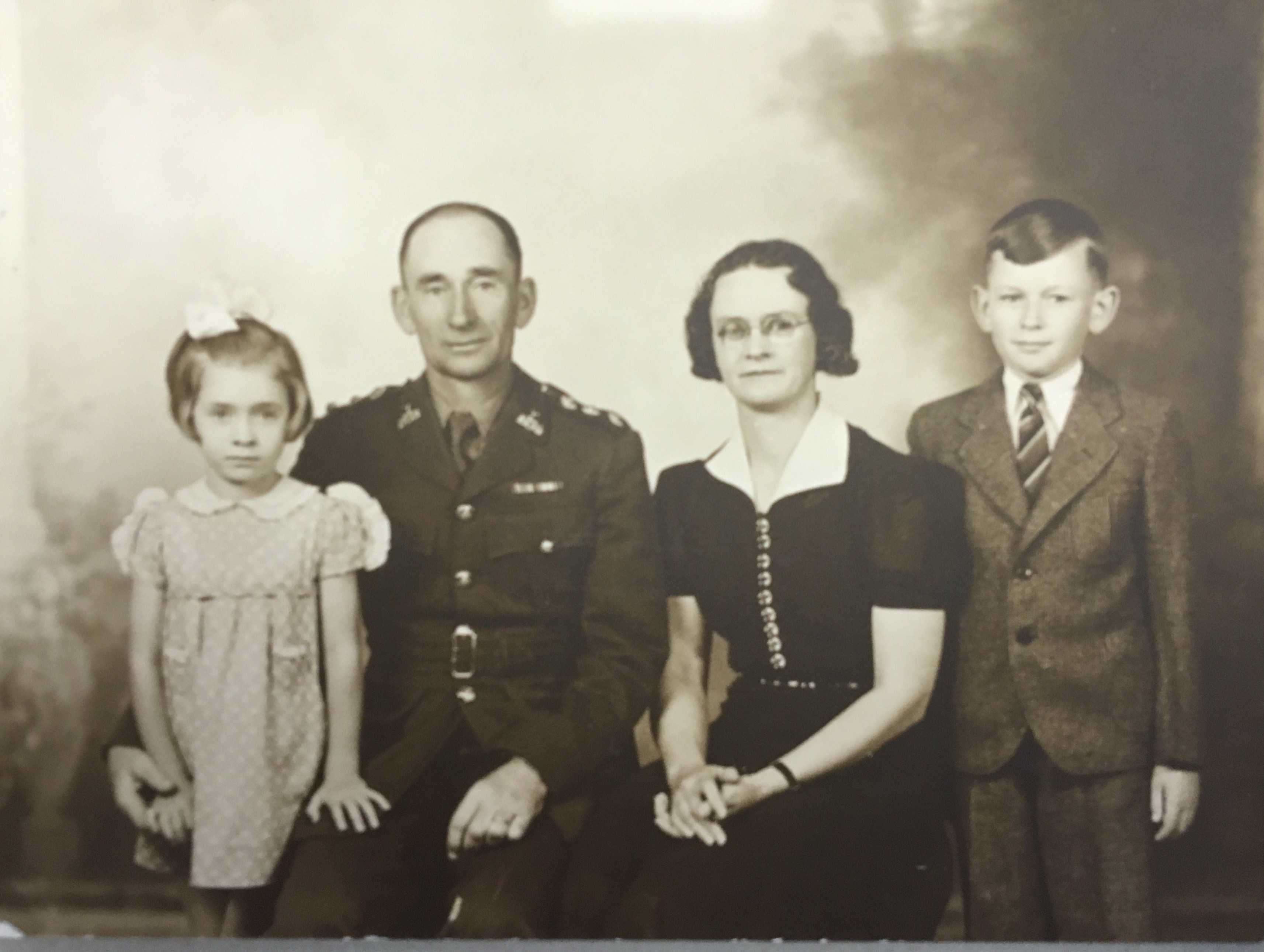 Photographie en noir et blanc – Archie, en uniforme, son bras droit autour de sa fille Margaret. Sa femme Grace est à gauche, et son fils Francis à gauche de celle-ci.